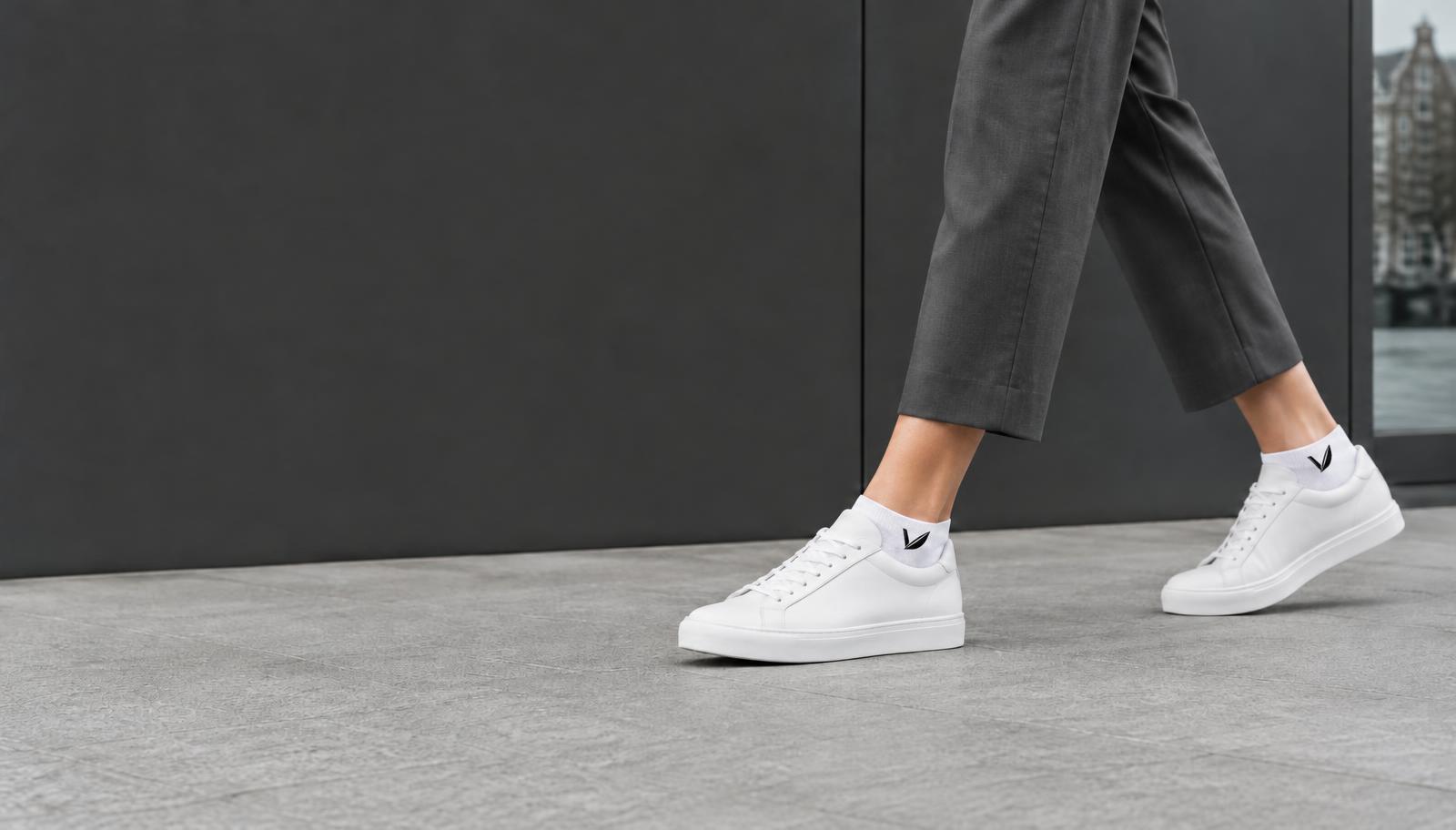 Witte Low Vlots met VLOTE-logo, onderweg langs een kantoorgebouw